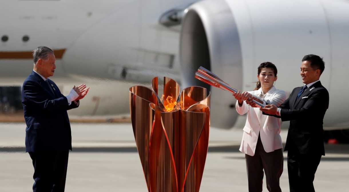 Os medalhistas de ouro olímpicos Tadahiro Nomura e Saori Yoshida posam depois de acender a chama olímpica, ao lado de Yoshiro Mori, presidente do comitê organizador das Olimpíadas de Tóquio 2020